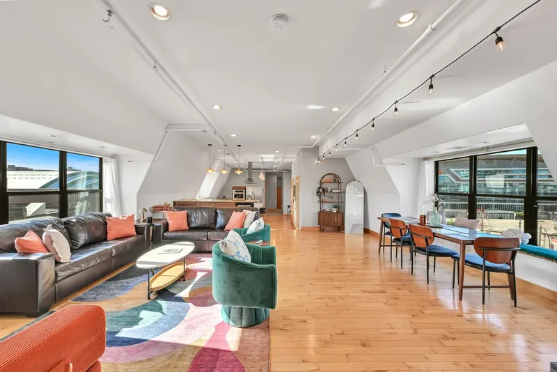 A long living and dining room at 3rd Street Retreat with tall windows and a view toward downtown