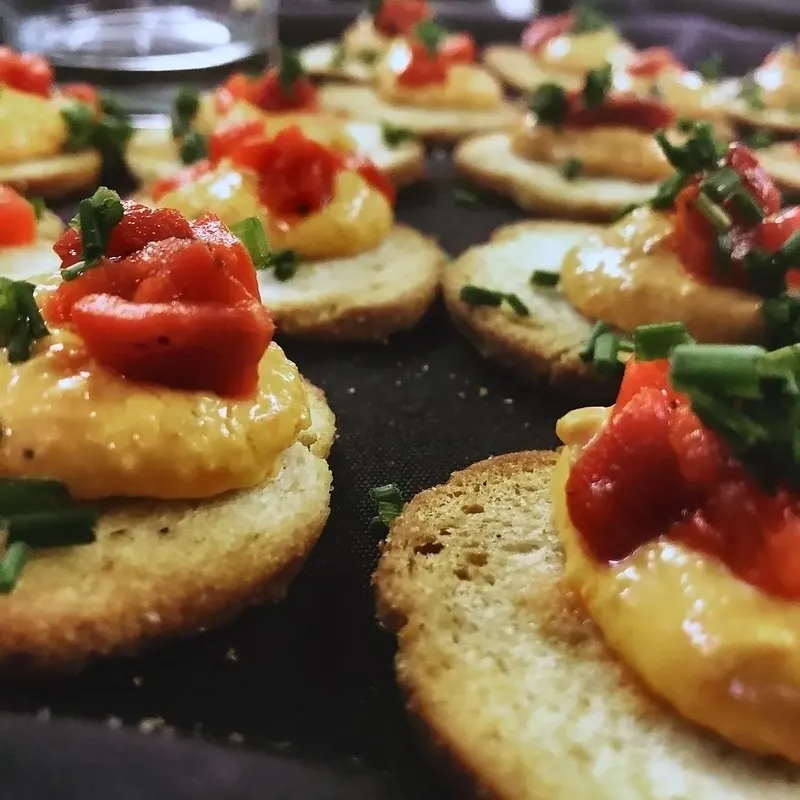 Toasted rounds topped with roasted red pepper spread and chives