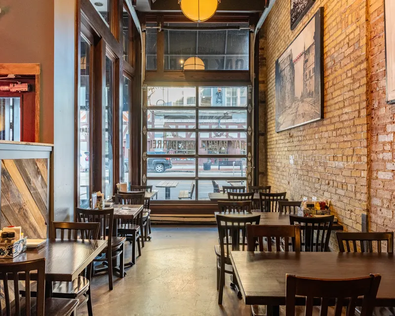 The dining room at Oak Barrel with its tables, red columns and screens along the wall
