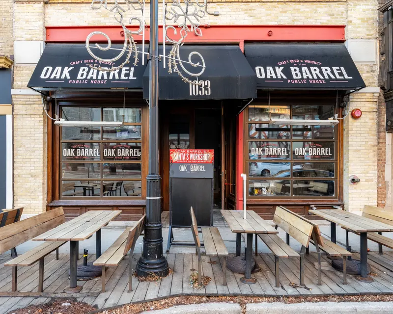 The Oak Barrel Public House storefront at 1033 with black awnings and a street-level patio, brick upper floors above