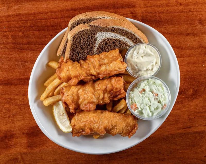 Beer-battered cod with fries, coleslaw, tartar sauce and rye bread on a white plate at Who's on Layton