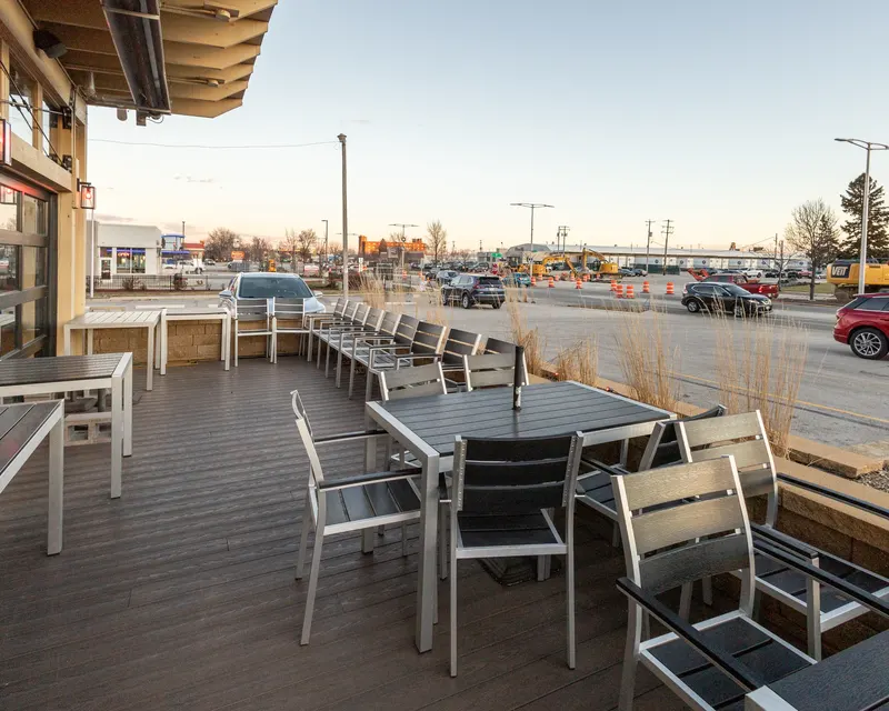 The patio tables outside Who's on Layton at sunset with Layton Avenue beyond