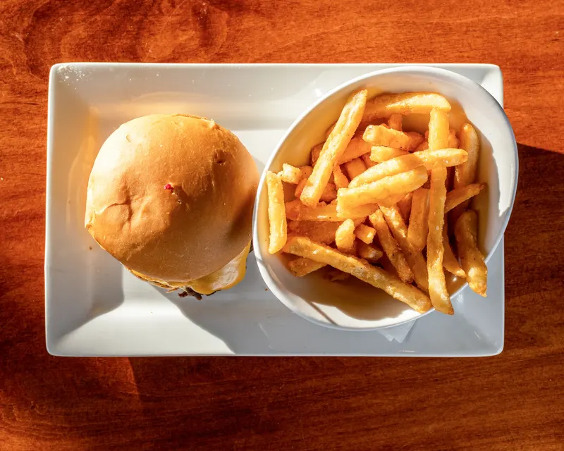 The tavern smash burger with a side of fries on a white plate at Who's on Layton